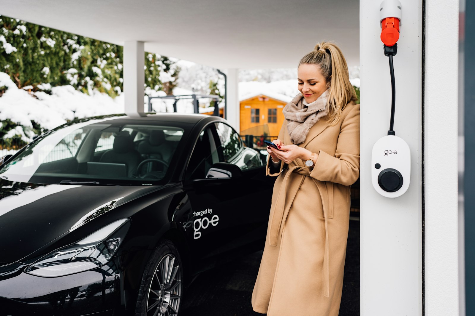 Khách sạc xe điện và thanh toán bằng điện thoại tại trạm sạc tự động